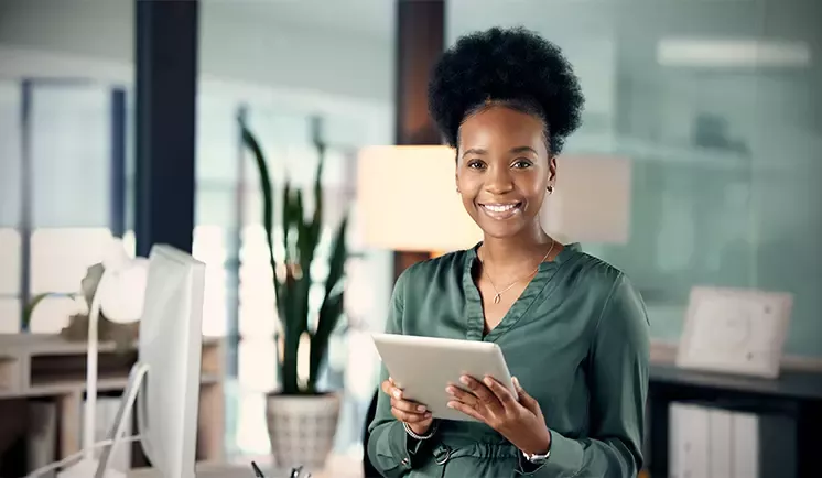 Smiling businesswoman holding tablet in office