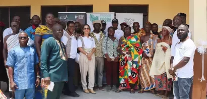 A diverse group of individuals in traditional and modern attire stands together, showcasing local culture and community engagement.