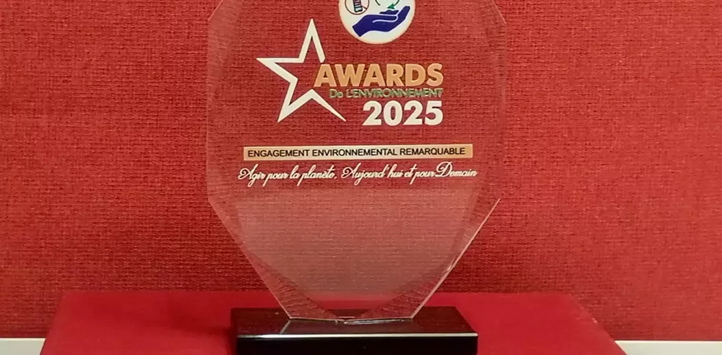 A crystal award for the 2025 Environmental Awards, featuring a star, with the text "Engagement environnemental remarquable" on a red background.