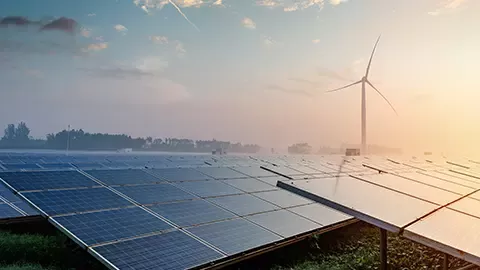 Solar panels with wind turbine in the background