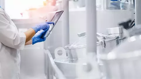 Scientist inspecting equipment in sterile laboratory